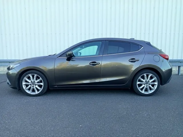 Brązowoszara Mazda 3 hatchback, widok z boku